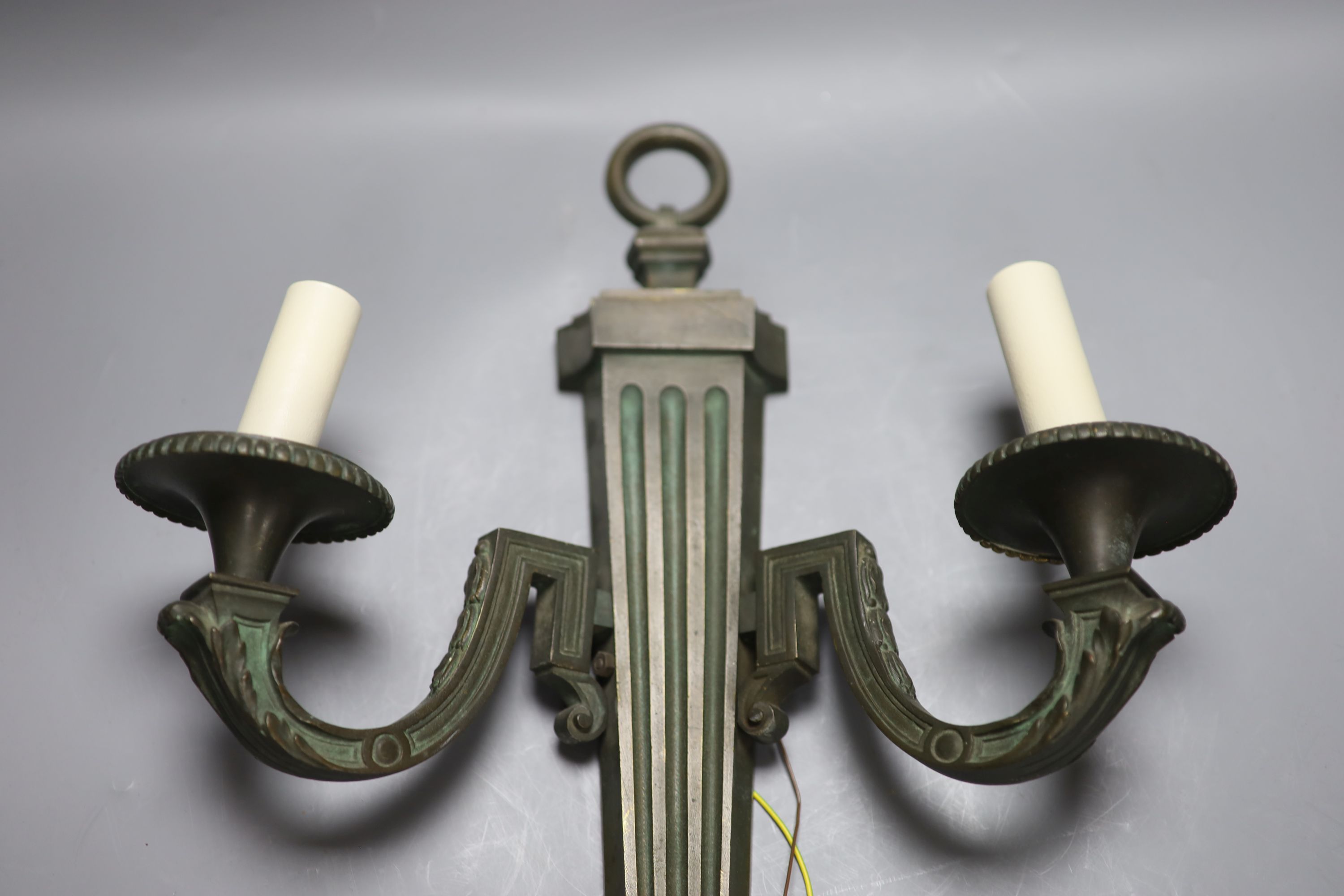A pair of bronze two branch wall lights, length 52cm